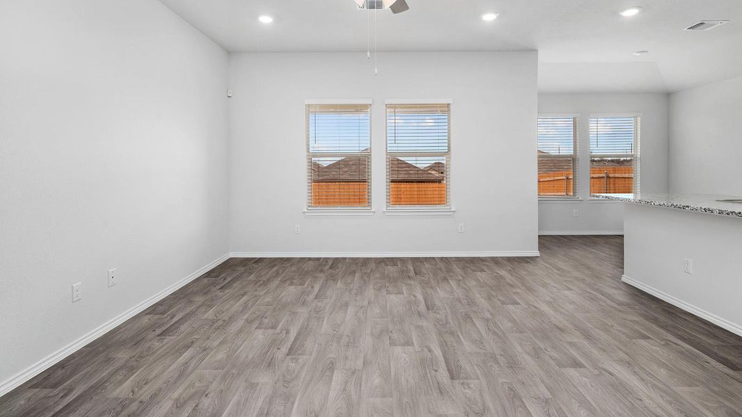 Spare room featuring light wood-style flooring, a ceiling fan, and recessed lighting