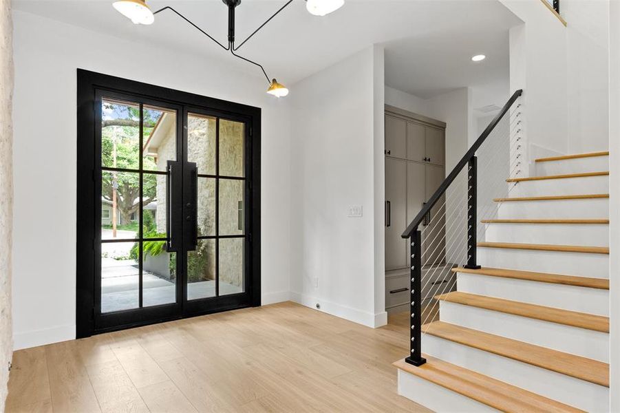Foyer entrance with stairs, light wood-style flooring, french doors, and recessed lighting