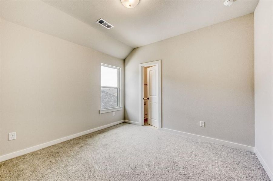 Spare room with light carpet and vaulted ceiling