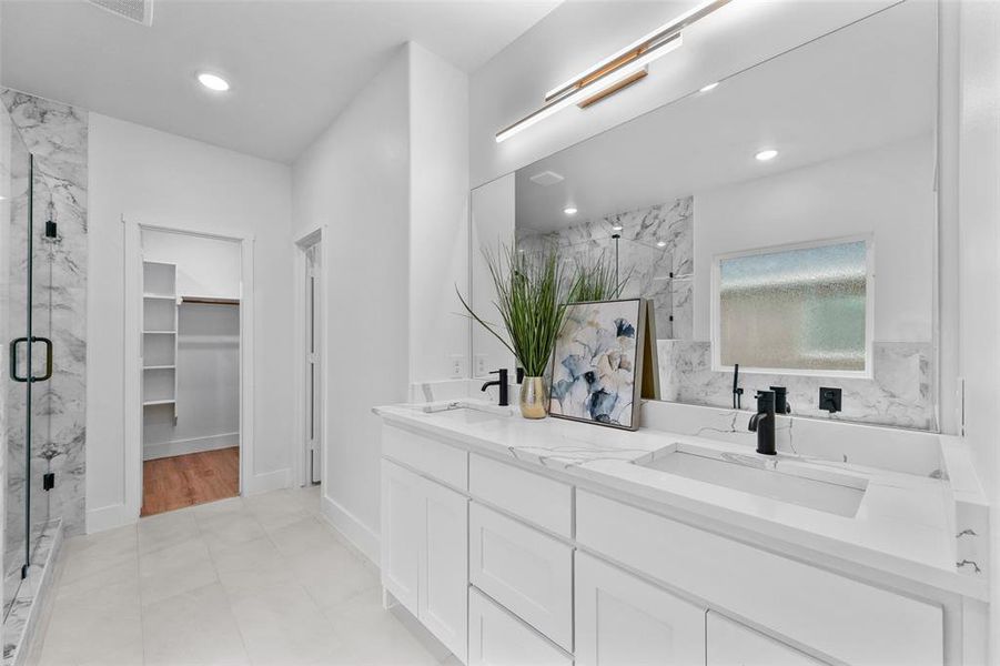 Bathroom featuring dual vanity with integrated sinks, white cabinetry, and matte black fixtures Bathroom featuring dual vanity with integrated sinks, white cabinetry, and matte black fixtures
