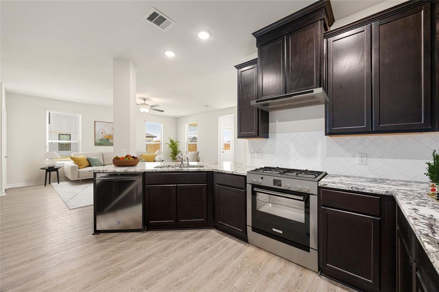 Sleek and contemporary, this kitchen offers stone countertops, stainless steel appliances, and a large island with pendant lighting. The open floor plan flows naturally into the living area, perfect for daily living and entertaining. Sleek and contemporary, this kitchen offers stone countertops, stainless steel appliances, and a large island with pendant lighting. The open floor plan flows naturally into the living area, perfect for daily living and entertaining.