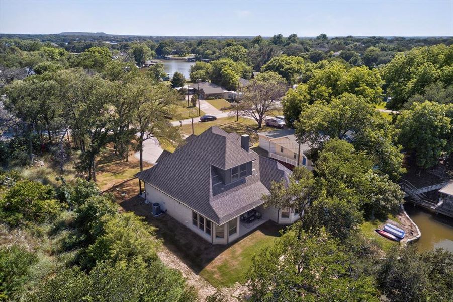 Aerial perspective showcasing a property with a multi-gabled roofline and light-colored siding