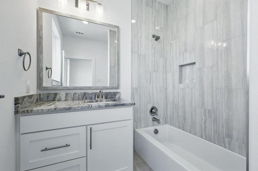 Full bath featuring visible vents, shower / bathing tub combination, and vanity