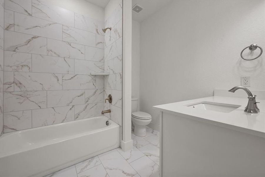 Bathroom featuring designer ceramic tile, vanity, and shower / tub combination. White very nice cabinetry throughout with Moen faucets.