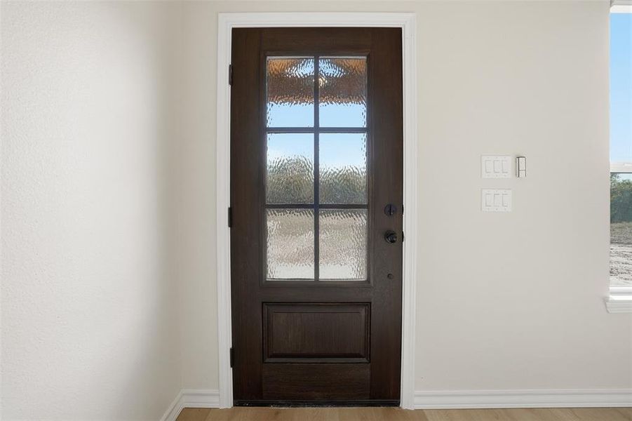Doorway to outside with wood finished floors and baseboards Doorway to outside with wood finished floors and baseboards