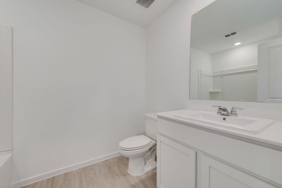 Bathroom with vanity, wood finished floors, and a bath