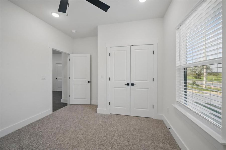 Unfurnished bedroom featuring baseboards, a ceiling fan, a closet, and carpet Unfurnished bedroom featuring baseboards, a ceiling fan, a closet, and carpet
