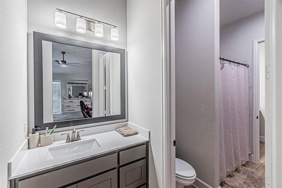 Bathroom vanity featuring a quartz countertop, undermount sink, and brushed nickel faucet