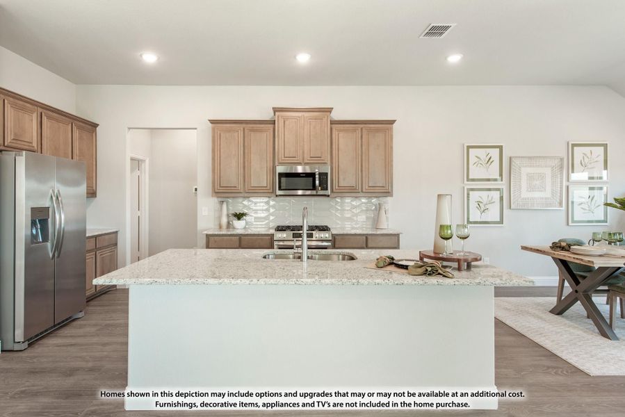 Kitchen with large granite island, light wood cabinets, stainless steel appliances, and tile backsplash Kitchen with large granite island, light wood cabinets, stainless steel appliances, and tile backsplash