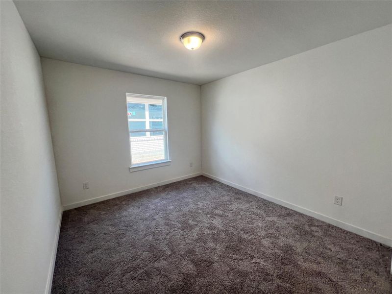 Empty room featuring dark carpet and baseboards Empty room featuring dark carpet and baseboards