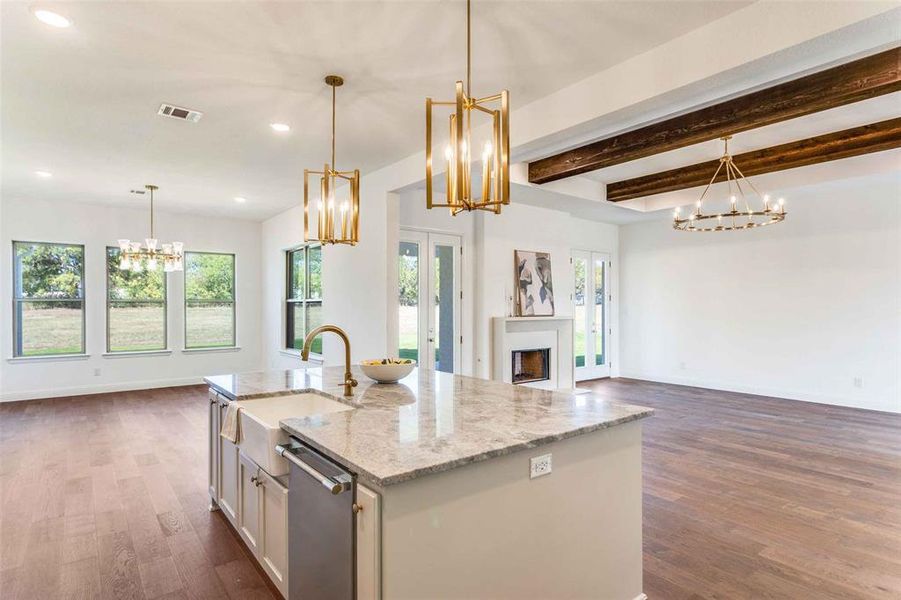 Kitchen featuring a chandelier, open floor plan, light stone countertops, beam ceiling, and recessed lighting Kitchen featuring a chandelier, open floor plan, light stone countertops, beam ceiling, and recessed lighting
