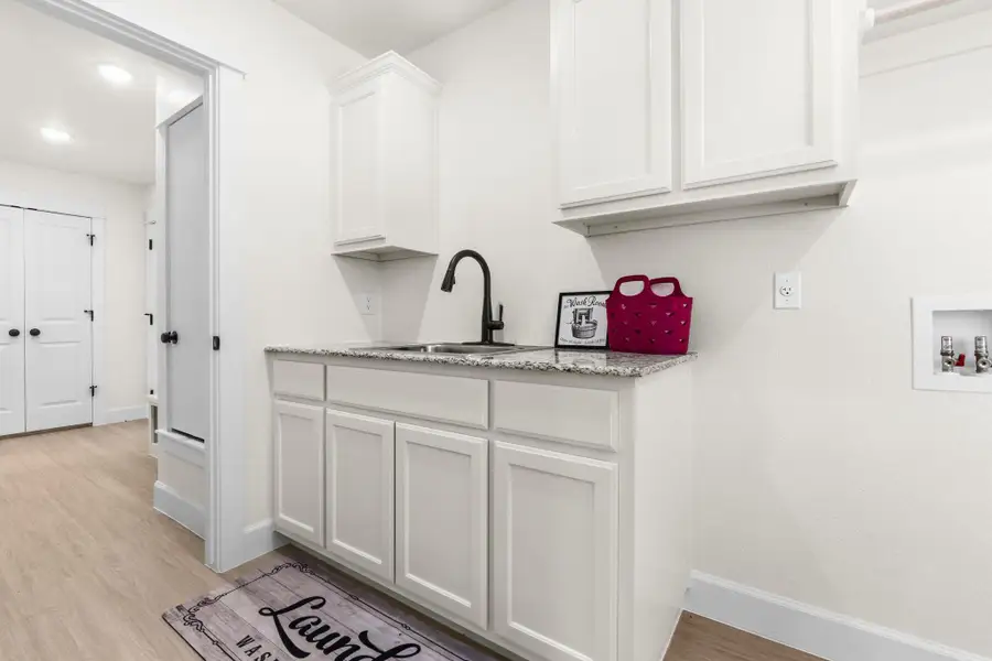 Washroom with light wood finished floors, hookup for a washing machine, and recessed lighting