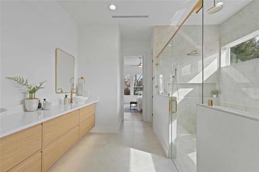 Bathroom with ensuite bath, a stall shower, double vanity, recessed lighting, and light tile patterned floors Bathroom with ensuite bath, a stall shower, double vanity, recessed lighting, and light tile patterned floors