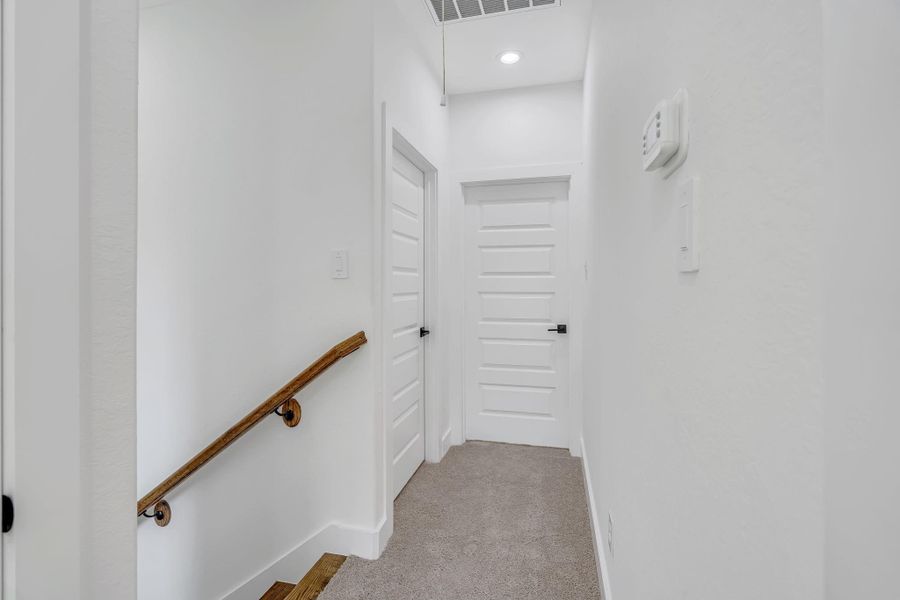 Second-floor landing featuring soft carpet flooring and access to the bedrooms, creating a comfortable and private upper-level retreat.