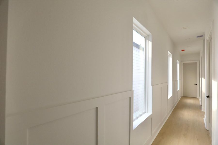 Hallway Craftsmanship – Exquisite trim-work frames the windows, showcasing fine attention to detail and elevating the hallway’s design. Hallway Craftsmanship – Exquisite trim-work frames the windows, showcasing fine attention to detail and elevating the hallway’s design.