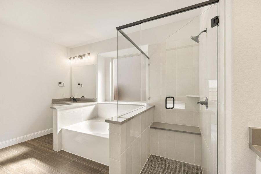 Bathroom with soaking tub, glass-enclosed walk-in shower, white tile walls, and wood-look floor tile