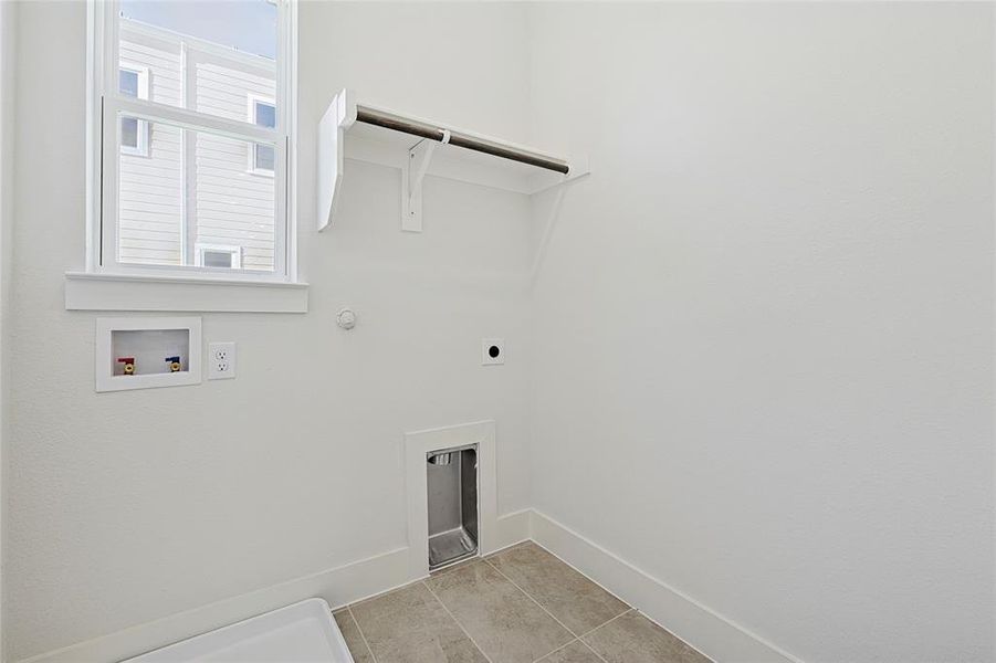 Laundry area with washer hookup, gas dryer hookup, hookup for an electric dryer, and light tile patterned floors Laundry area with washer hookup, gas dryer hookup, hookup for an electric dryer, and light tile patterned floors