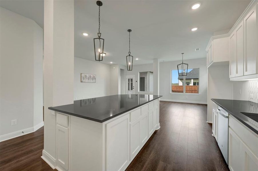 Kitchen with white cabinetry, dark wood-style floors, a large island, and dishwashing machine