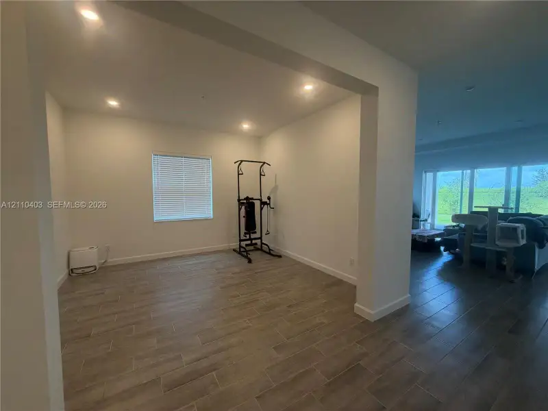 Open-concept interior featuring wood-finish tile flooring and recessed lighting