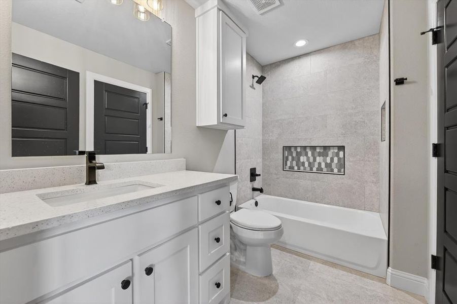 Bathroom featuring a white vanity with a light-toned countertop, an integrated sink, and black hardware