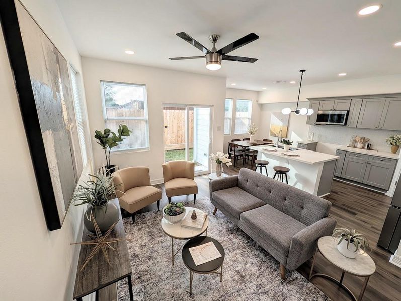 The 11' x 17' (approx.) living area utilizes an open concept flow that connects seamlessly to the dining zone. Large windows provide a steady stream of natural light across the engineered wood-style flooring.