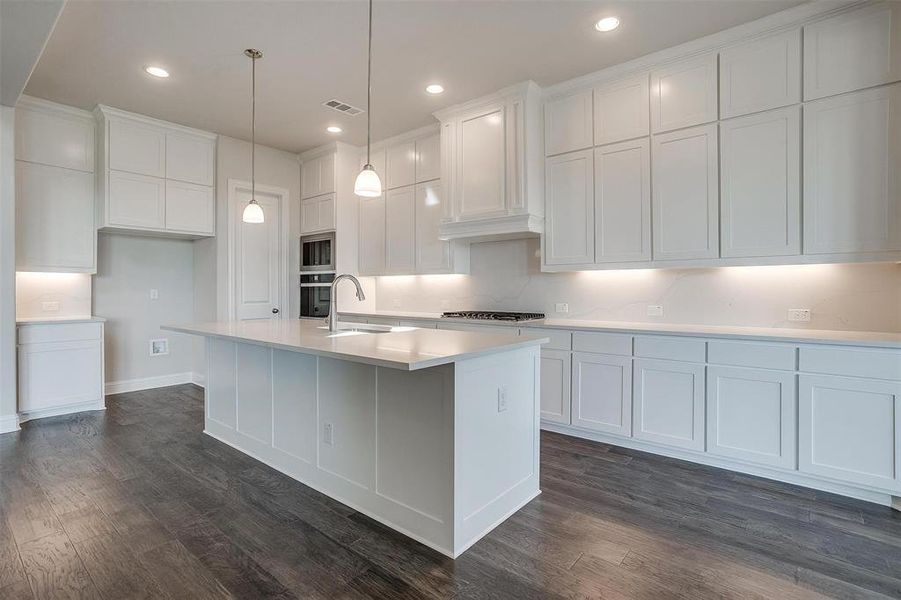 Kitchen with white cabinetry, a center island with sink, dark hardwood / wood-style floors, and sink