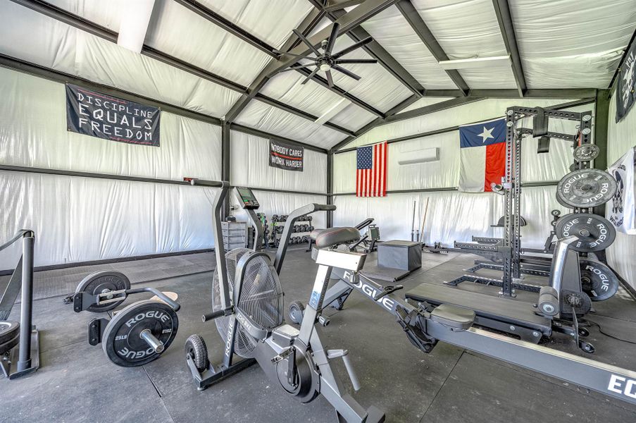 Another view of the interior gym space showcases the high ceilings, open layout, and room for a wide variety of fitness equipment and activities. The flexible design and generous space make this a unique addition to the property with endless potential uses.