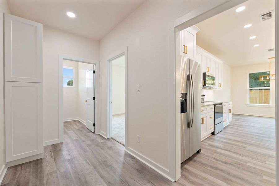 Corridor featuring recessed lighting, light wood finished floors, and healthy amount of natural light Corridor featuring recessed lighting, light wood finished floors, and healthy amount of natural light