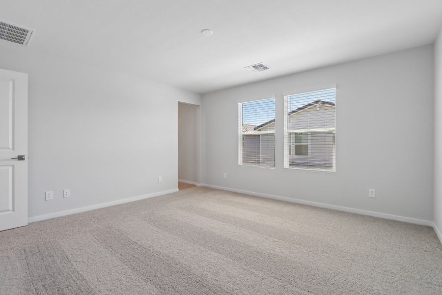 A room with a carpet and windows.