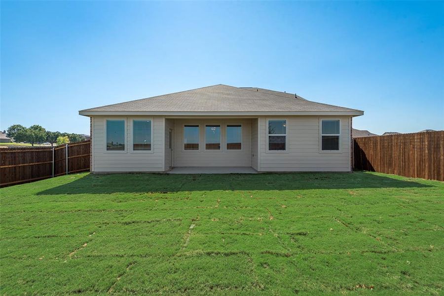 Back of house with a lawn and a patio area