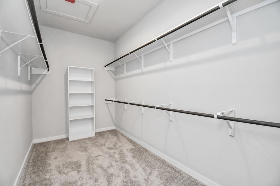 Primary bedroom walk-in closet that epitomizes luxury and practicality. This generously sized space features built-in shelving, offering abundant room for impeccable organization. High ceilings and recessed lighting create a bright and welcoming ambiance. Sample photo of completed home with similar floor plan. Actual colors and selections may vary. Primary bedroom walk-in closet that epitomizes luxury and practicality. This generously sized space features built-in shelving, offering abundant room for impeccable organization. High ceilings and recessed lighting create a bright and welcoming ambiance. Sample photo of completed home with similar floor plan. Actual colors and selections may vary.