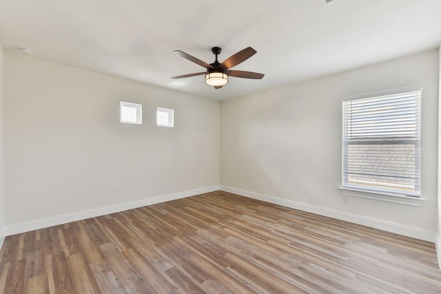 Bedroom 4 with light wood-type flooring, baseboards, and a ceiling fan Bedroom 4 with light wood-type flooring, baseboards, and a ceiling fan