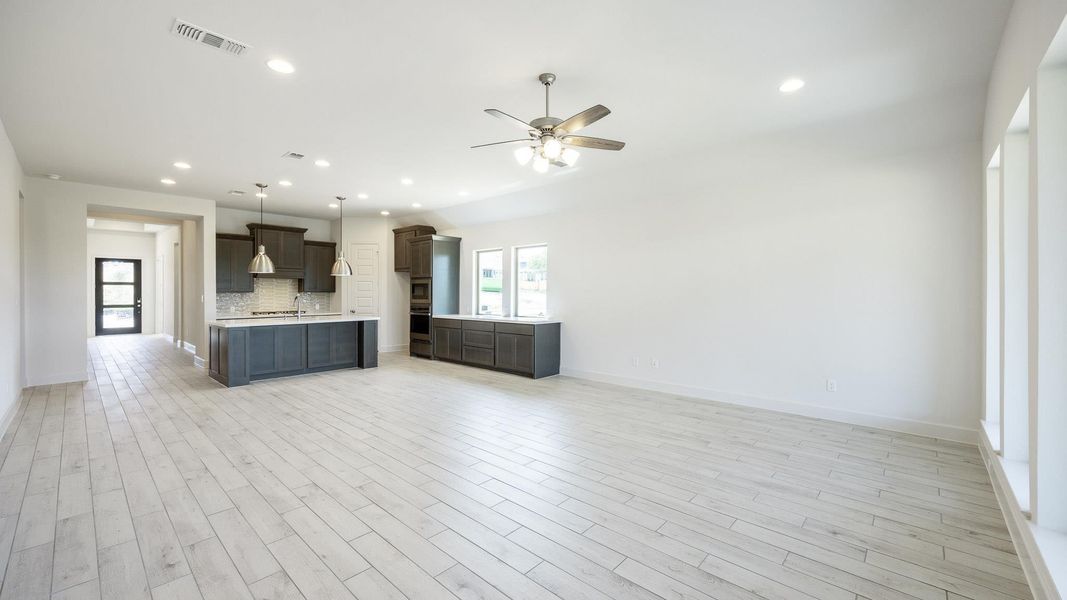 Kitchen featuring open floor plan, light countertops, ceiling fan, decorative backsplash, and recessed lighting Kitchen featuring open floor plan, light countertops, ceiling fan, decorative backsplash, and recessed lighting