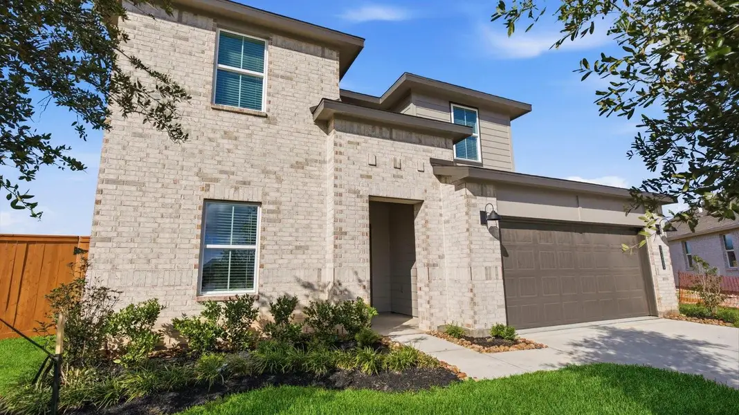 A two-story home with brick and stone exterior with a two-car garage and a well-maintained front lawn in Texas City A two-story home with brick and stone exterior with a two-car garage and a well-maintained front lawn in Texas City