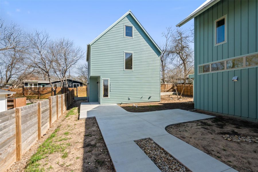 Rear view of property featuring board and batten siding, fence private yard, and a patio