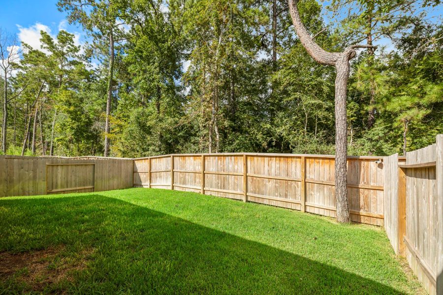 This private backyard includes lush green grass and a sturdy wooden fence, surrounded by mature trees, offering a serene and secluded outdoor space. This private backyard includes lush green grass and a sturdy wooden fence, surrounded by mature trees, offering a serene and secluded outdoor space.