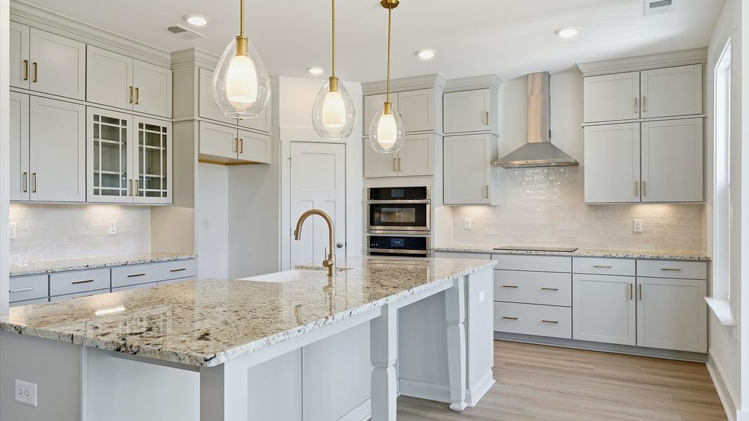 Vibrant and open kitchen centered around a 9-foot island with elegant pendant lighting above located in Woodruff, SC