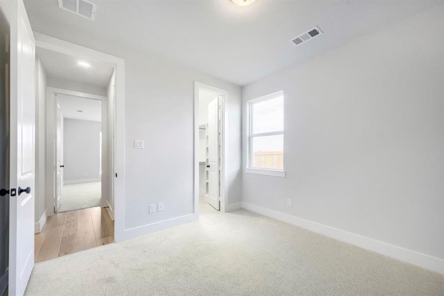 Carpeted room with a single pane window providing natural light
