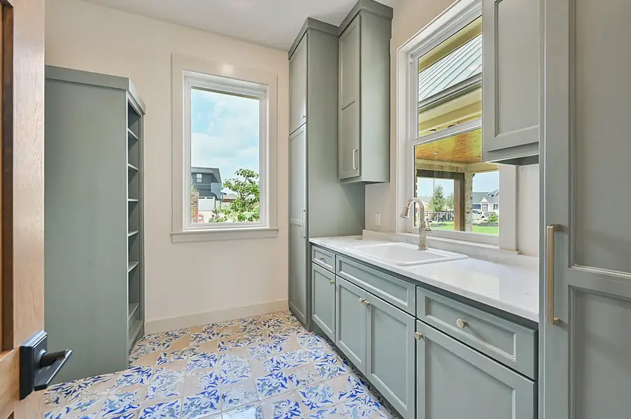 Utility room with tons of storage and sink. Gorgeous tile floors