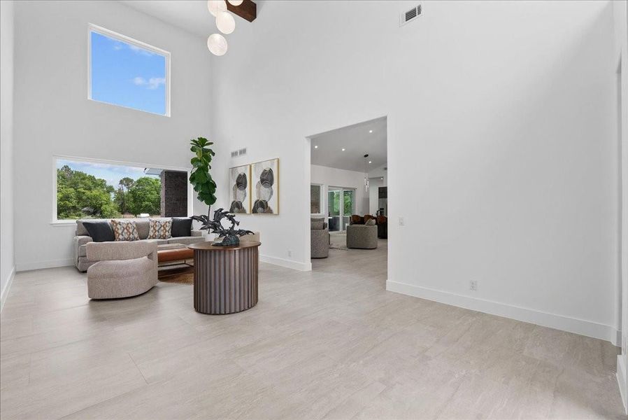 Luxury is in the details. This light-filled entry features imported Italian tile flooring and oversized windows that frame the property’s lush, oak-canopied grounds.