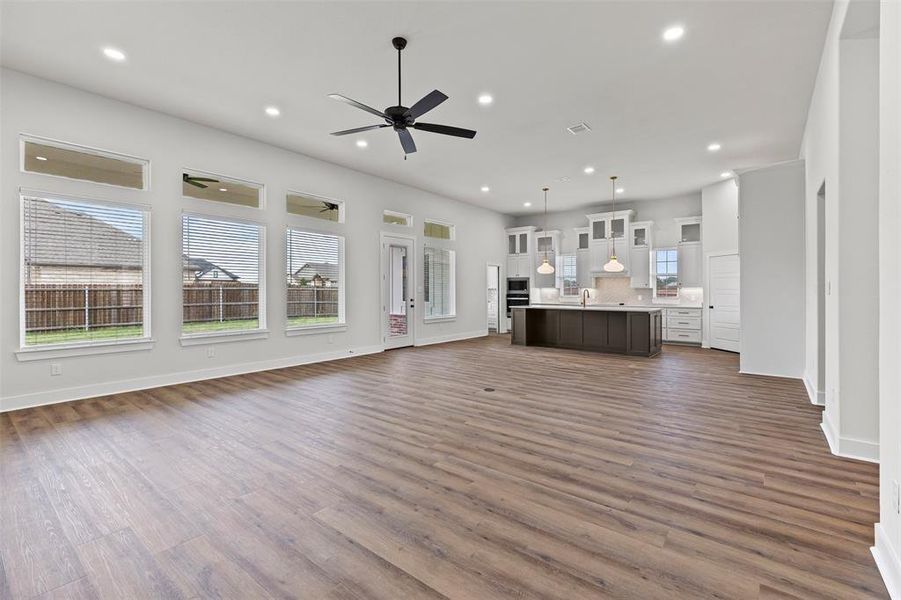 Unfurnished living room with recessed lighting, dark wood finished floors, and a ceiling fan Unfurnished living room with recessed lighting, dark wood finished floors, and a ceiling fan