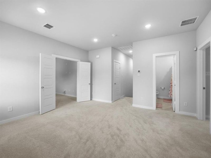 Unfurnished bedroom featuring light colored carpet, recessed lighting, and connected bathroom
