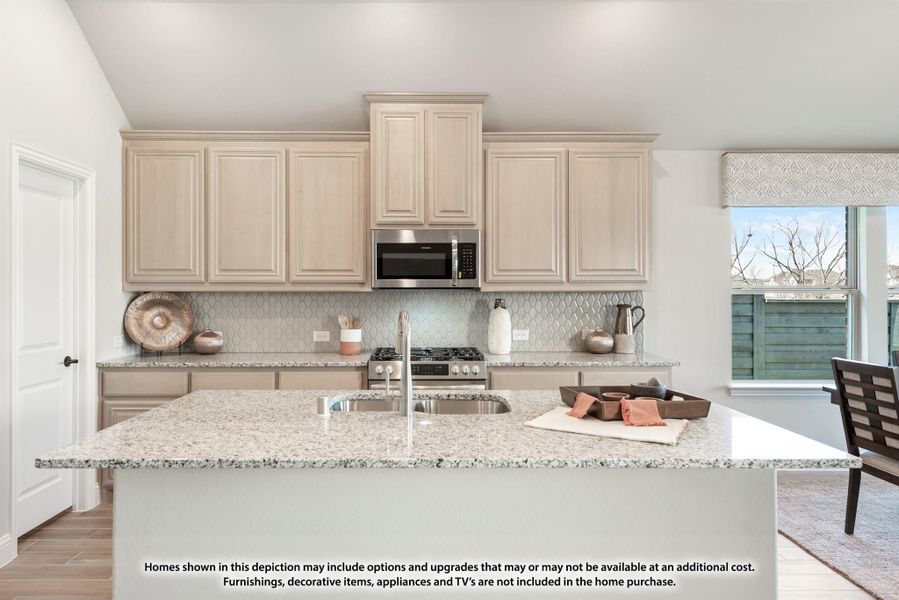 Kitchen with large granite island, cream cabinets, tile backsplash, and stainless steel appliances