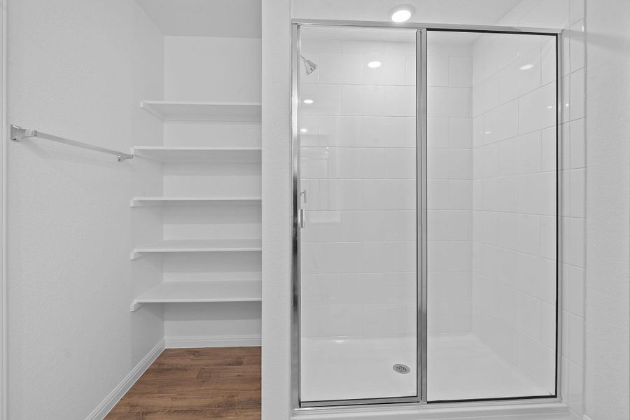 Bathroom featuring dark wood-style floors and a shower stall