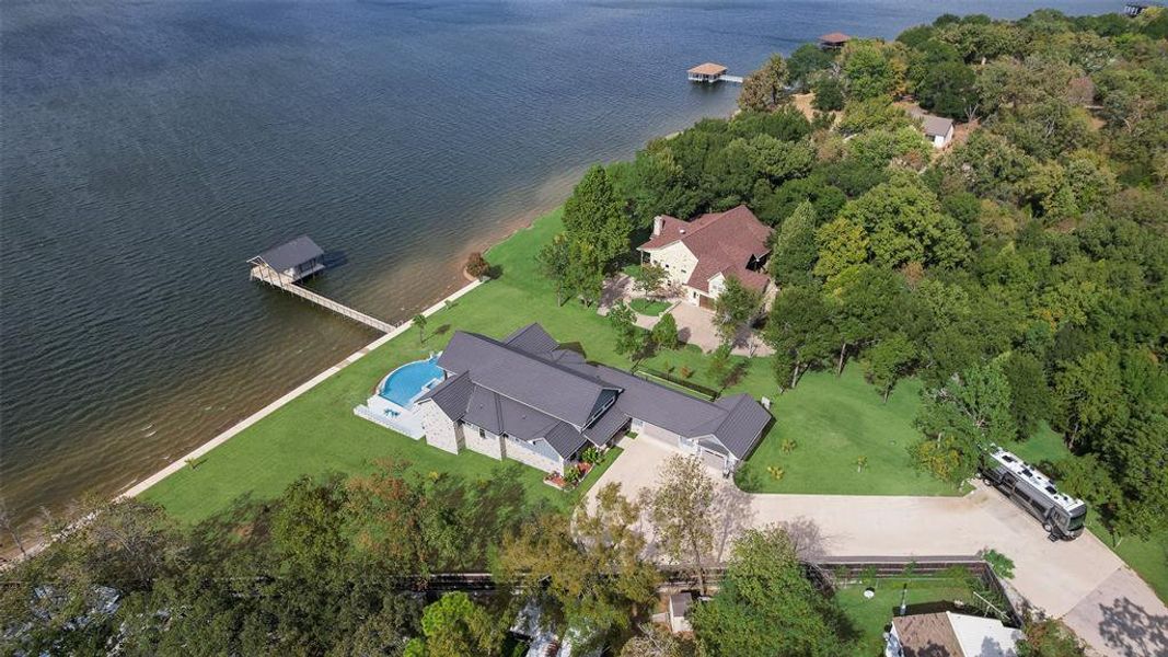 Aerial view of property's location featuring a pool area and a nearby body of water Aerial view of property's location featuring a pool area and a nearby body of water