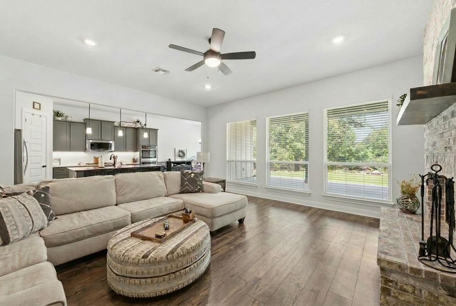 An inviting open-concept living space features warm hardwood floors and a cozy brick fireplace. An inviting open-concept living space features warm hardwood floors and a cozy brick fireplace.