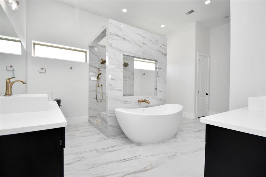 Primary bathroom with stand alone soaker tub and walkthrough shower