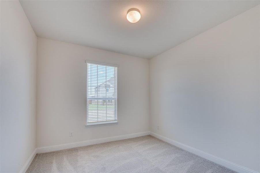 Spare room featuring light colored carpet and baseboards