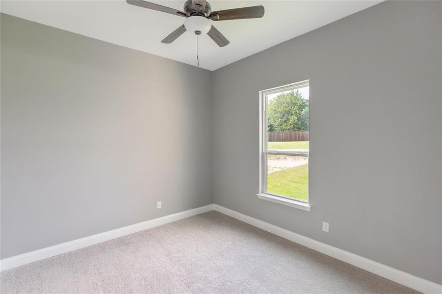 Spare room with plenty of natural light, carpet flooring, and ceiling fan