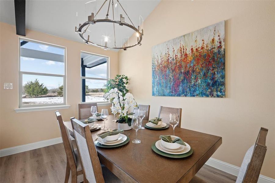 Dining area with vaulted ceilings and wood-finish flooring Dining area with vaulted ceilings and wood-finish flooring